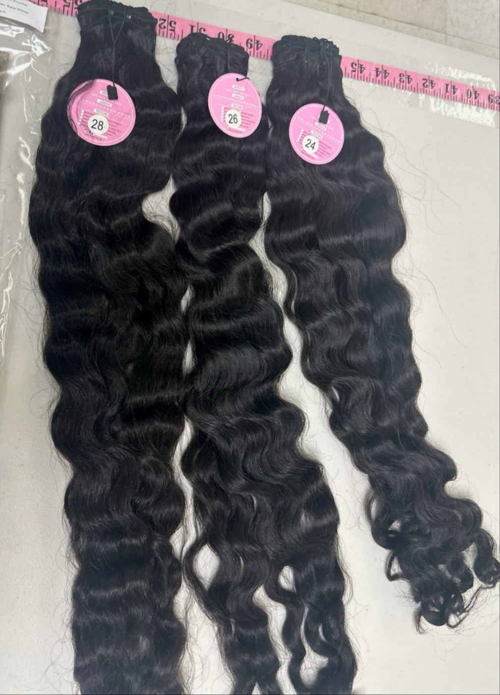 Three bundles of Raw Malaysian Curly Wave extensions.